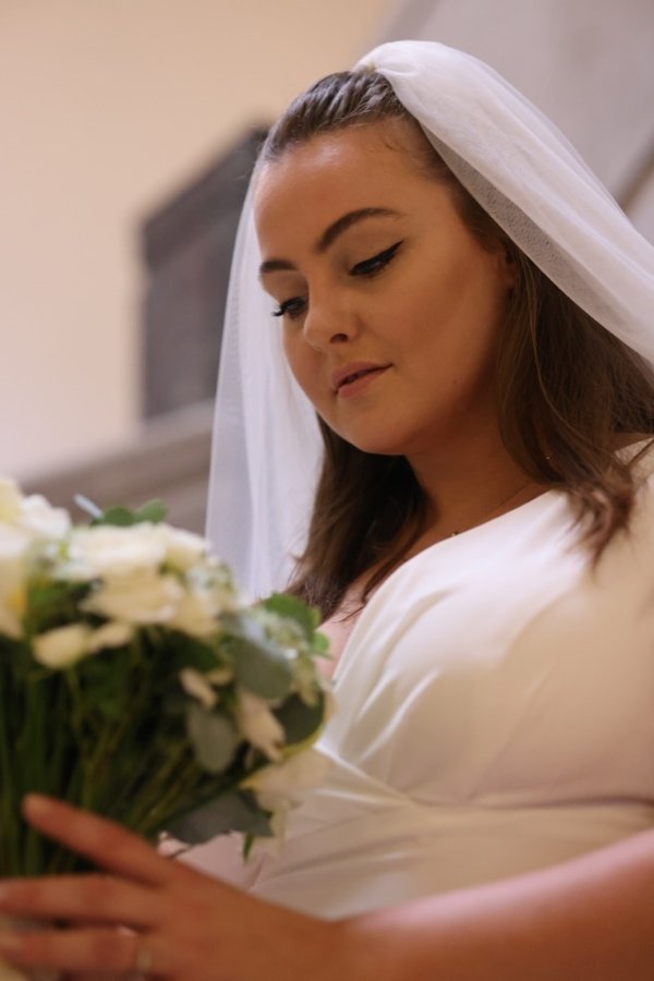 Bride holding bouquet, looking down